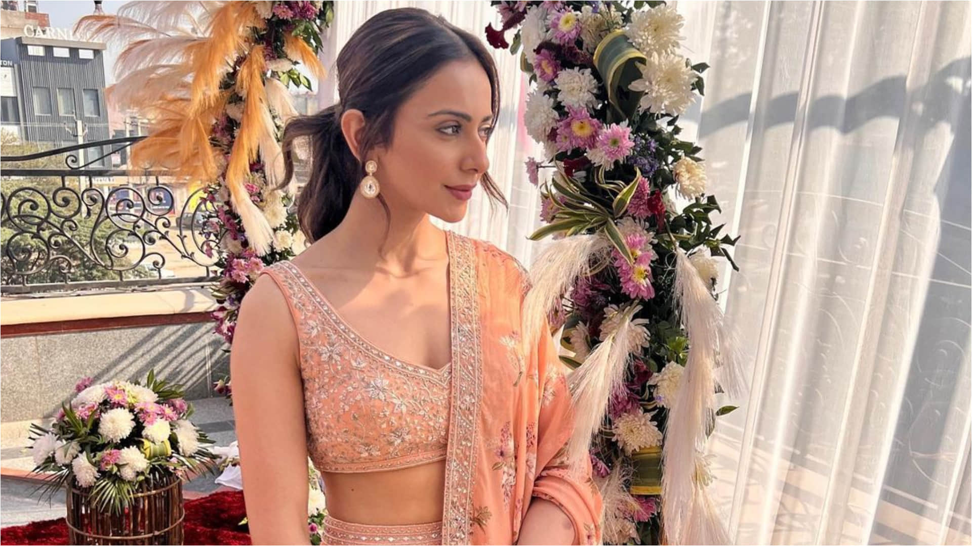 rakul preet singh poses in sunkissed light at wedding wearing peach printed lehenga