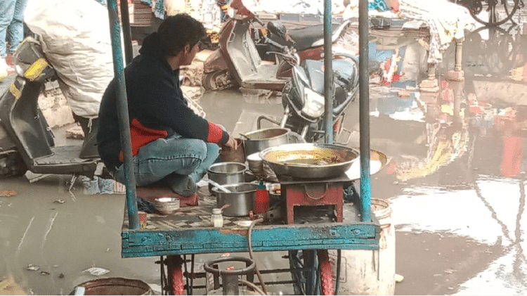 जलभराव होने से ठेले पर बैठा युवक