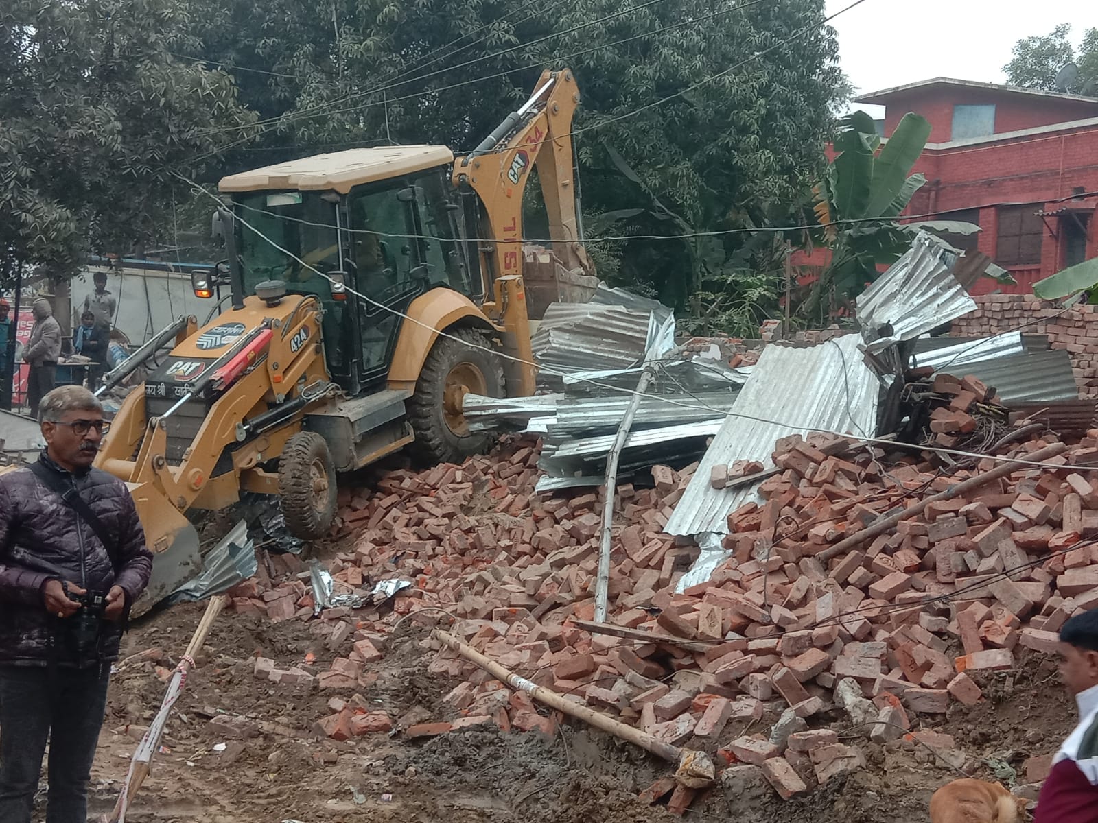 Women lay down in front of JCB in Varanasi JCB arrived to break shops in Bhikharipur, fierce ruckus