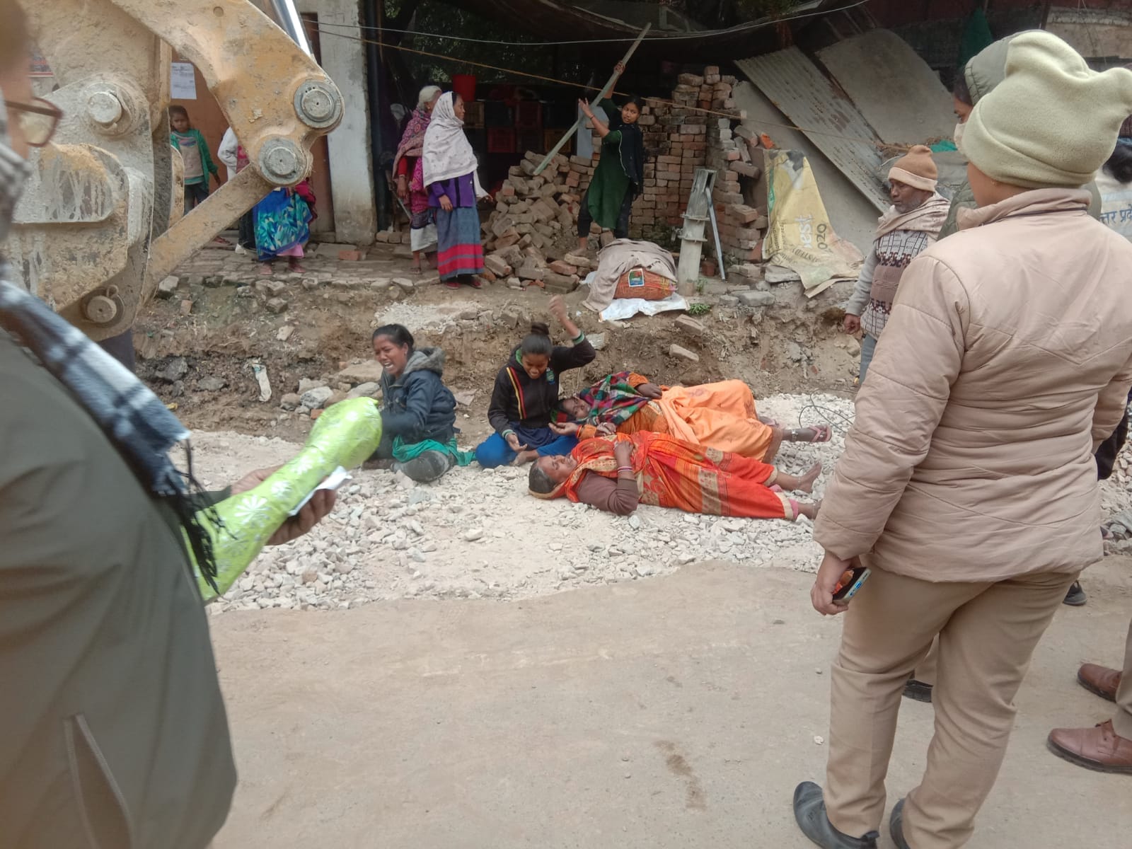 Women lay down in front of JCB in Varanasi JCB arrived to break shops in Bhikharipur, fierce ruckus
