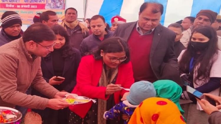 बच्चे को अन्नप्राशन कराती हाथरस डीएम अर्चना वर्मा