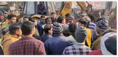 ट्रैफिक चौराहे पर बुल्डोजर चलते समय व्यापारियों से कर्मचारियों की होती नोंकझोंक