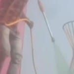 घास पर हरे रंग का स्प्रे करता कर्मचारी