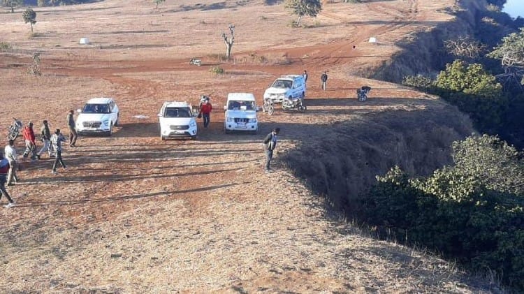 उमरिया में पहाड़ से गिरे युवक को निकालने की जद्दोजहद करते लोग।