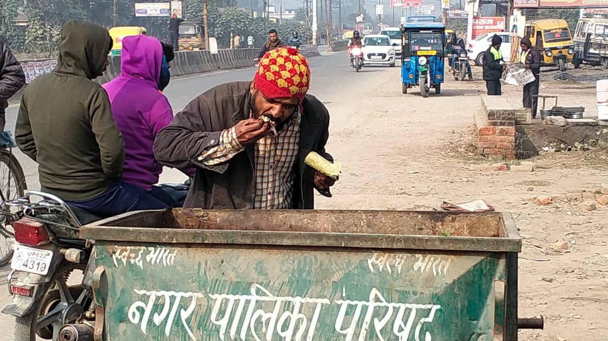 person started eating food thrown in the garbage People passing through the road remained heartless
