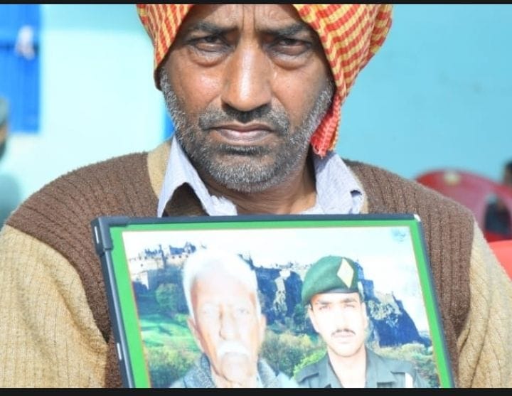 Father is sitting with the photo of the beloved on the chest
