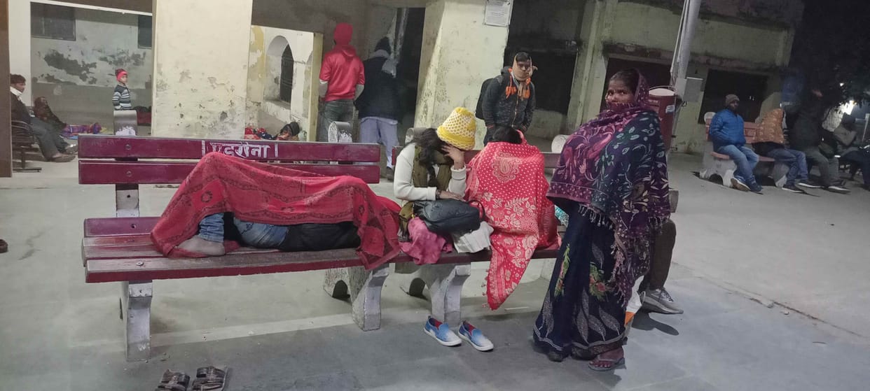 Passengers wait for the train by sleeping on the floor in the cold night
