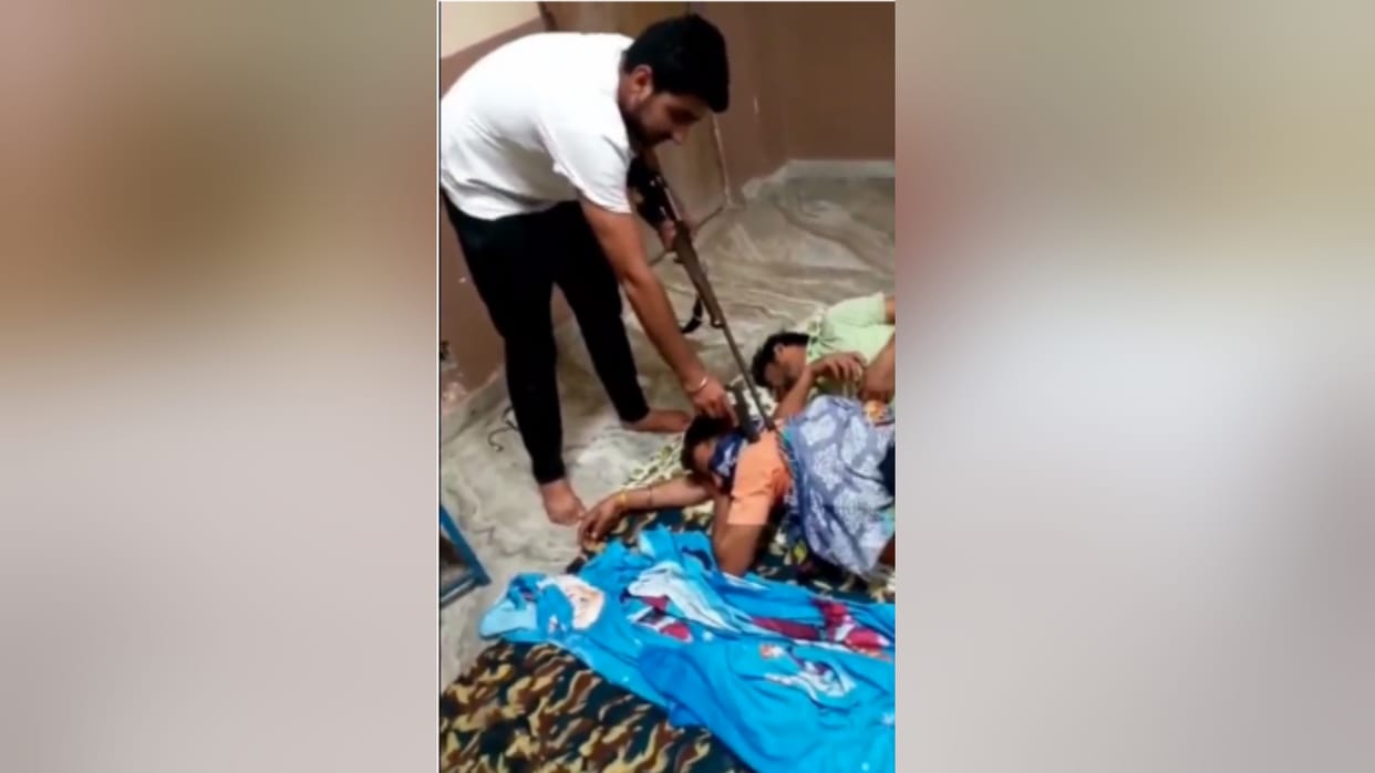 young man pointing weapon at sleeping people Video viral on Twitter with pistol and rifle in sambhal