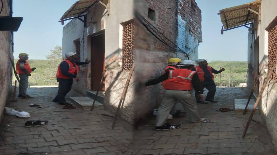 laborers are breaking dilapidated buildings with hammers in teela Maithan at Agra