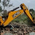 जम्मू कश्मीर में अतिक्रमण हटाती जेसीबी