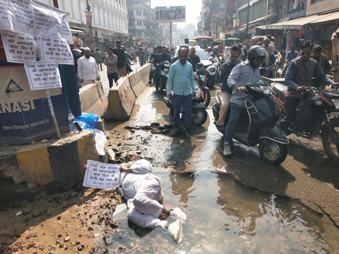 Protest by former councilor by lying in pit said water flowing on varanasi nai sadak road