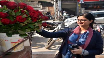 गुलाब के फूल देखती युवती