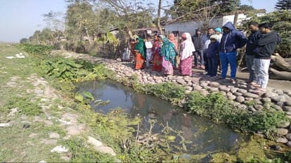 नाले के पास खड़े ग्रामीण