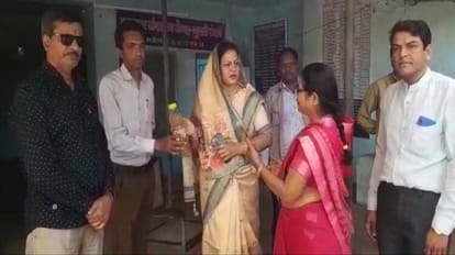 उपयंत्री को गंदे पानी की बोतल सौंपतीं पार्षद माया राजेश