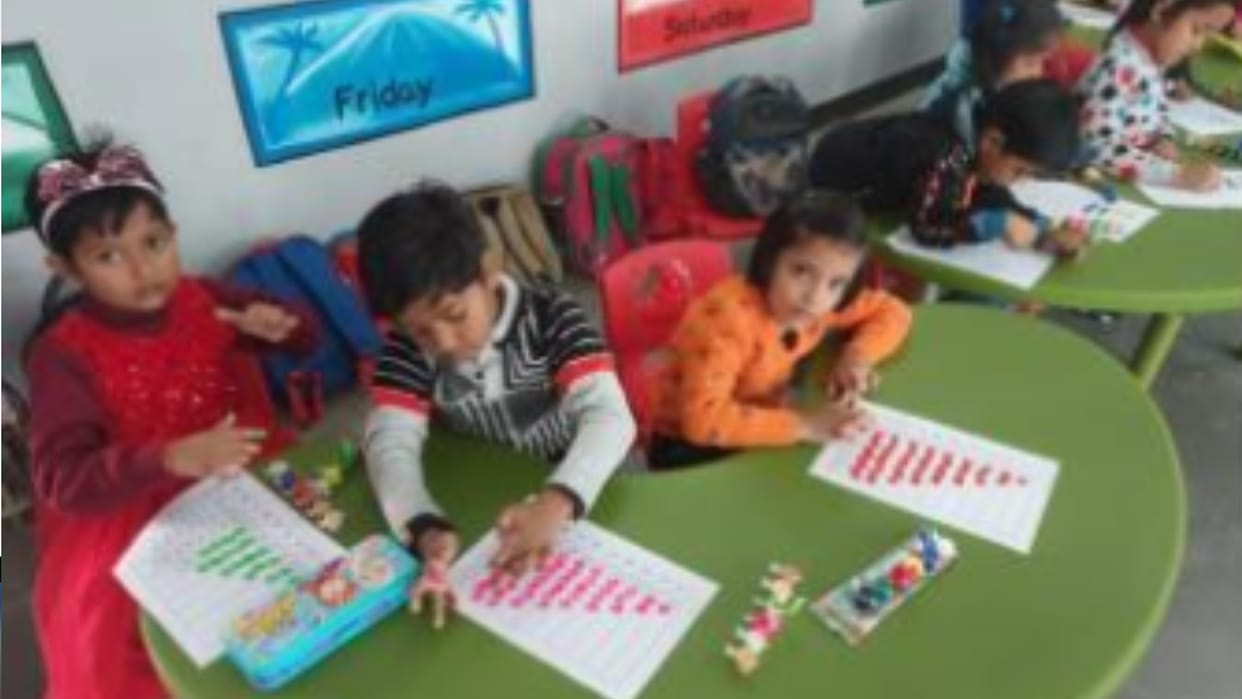 Children studying from pictures engraved on walls