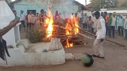 हत्या के आरोपी के घर के सामने शव को जलाते आदिवासी समाज के लोग