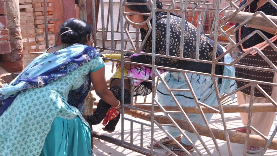Doctors and patients climb over wall to reach hospital at TB department of SN Medical College in Agra