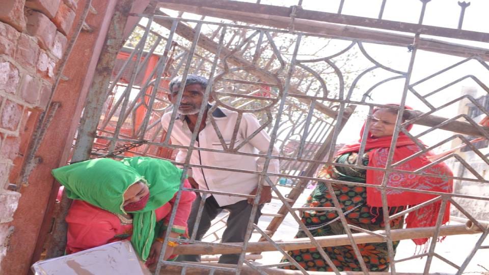 Doctors and patients climb over wall to reach hospital at TB department of SN Medical College in Agra