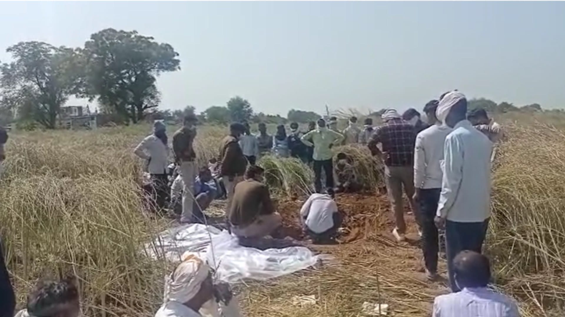 शव को खेत से बाहर निकालती पुलिस