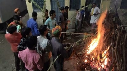 हाथरस के दिल्ली वाला मोहल्ला में देर शाम होलिका दहन करते लोग