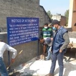 गांव बसौदी में राजेश उर्फ मोटा की संपत्ति अटैच करने का नोटिस लगाती एनआईए व सीआईए-2 की टीम।