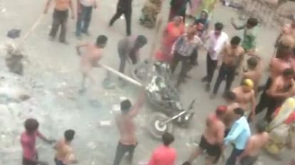 बाइक पर लाठी-डंडे बरसाते लोग