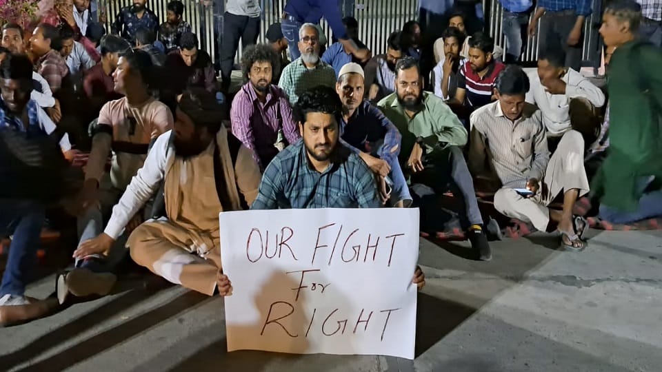 AMU temporary workers sit on dharna at night