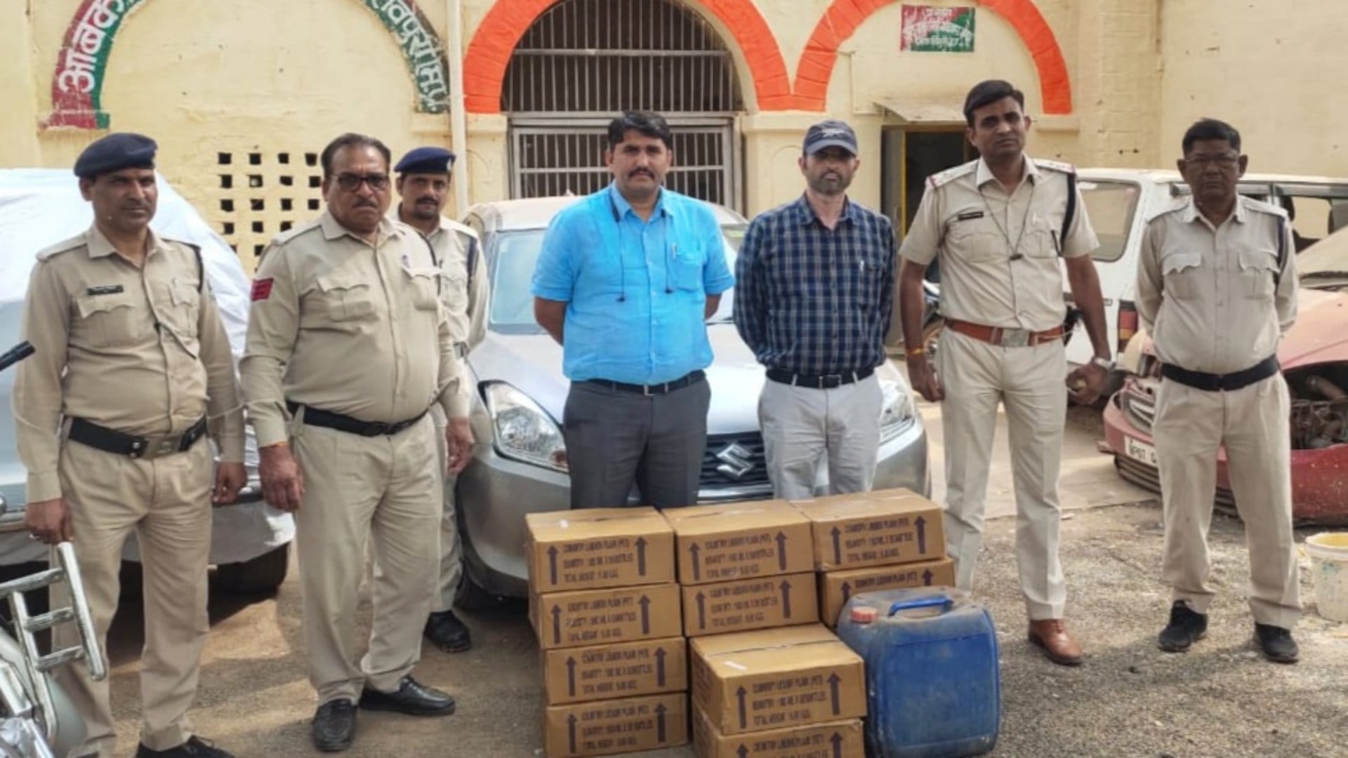 जब्त की गई शराब के साथ आबकारी विभाग के अधिकारी और पुलिस