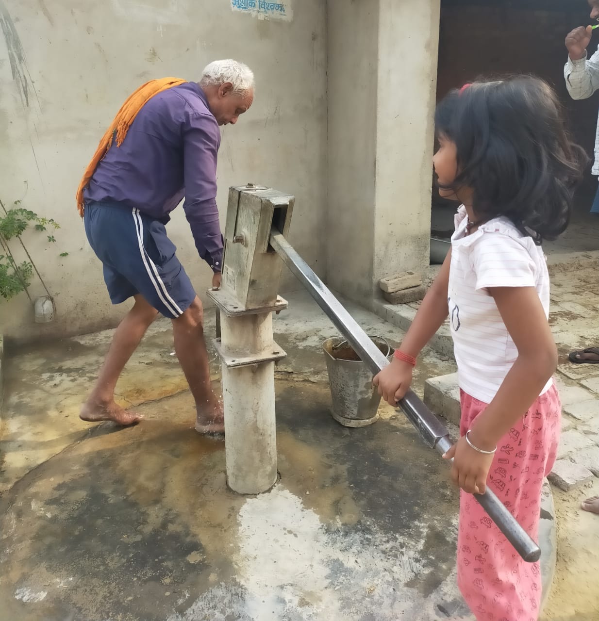 People troubled by protest of electricity workers forced to fill water with buckets on hand pump