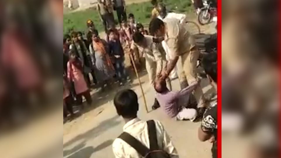 Policeman beat middle aged man in the middle of the road