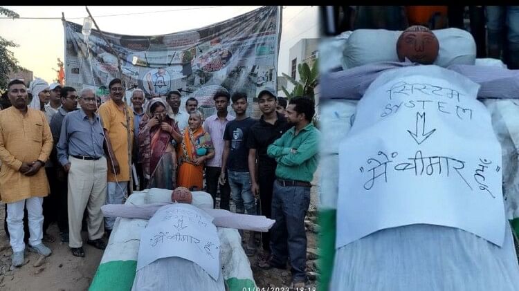 Agra : आगरा में अनोखा प्रदर्शन, सरकारी सिस्टम का बनाया पुतला, लिखा ‘मैं बीमार हूं’, लगाई ग्लूकोज की बॉटल