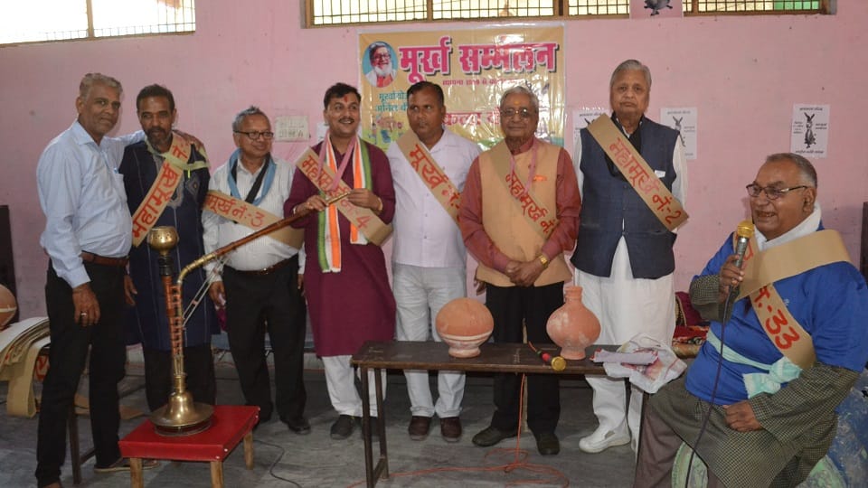 Mahamurkh Sammelan Offering pot by sitting on  cot garland made of potatoes