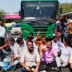 सड़क पर बैठे आम आदमी पार्टी के कार्यकर्ता।