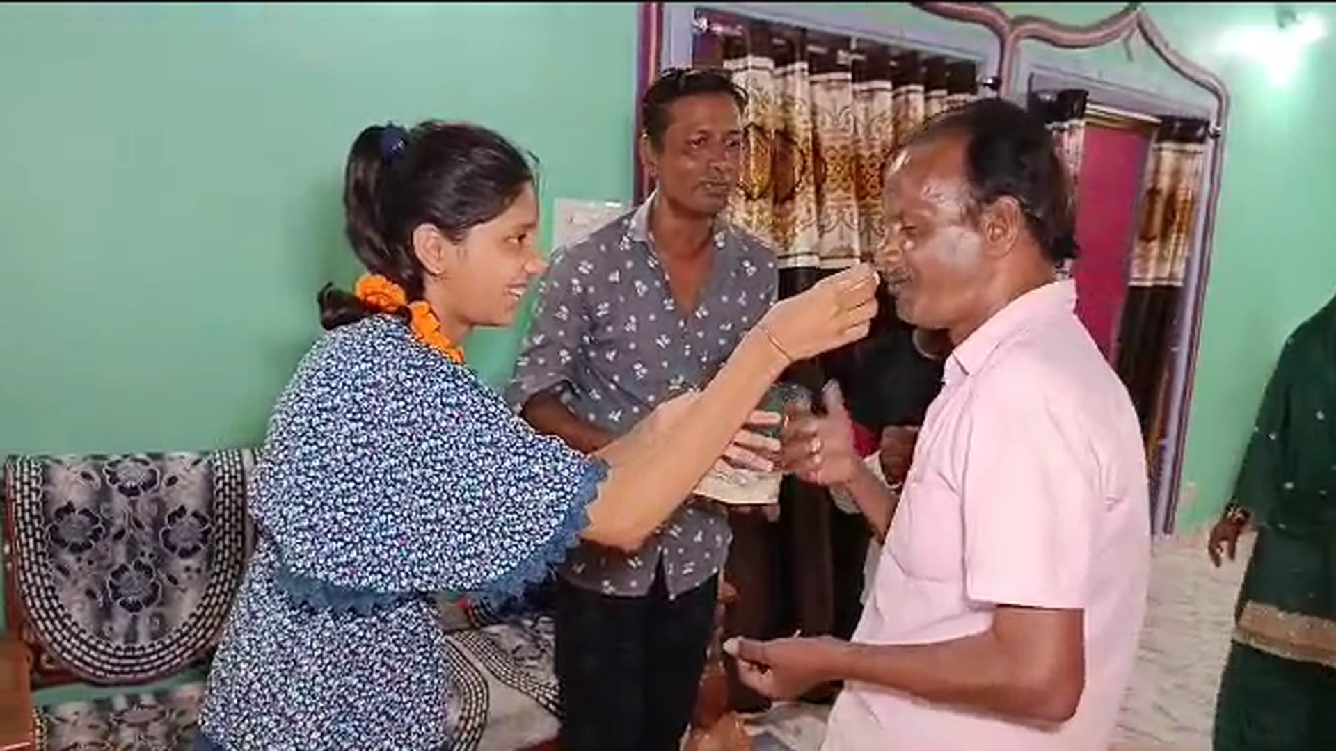 परीक्षा परिणाम आने के बाद पिता को मिठाई खिलाती नरगिस।