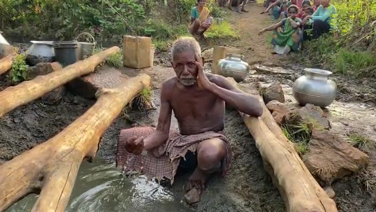 chhattisgarh villager quenching thirst with dirty water by digging pit in Kanker