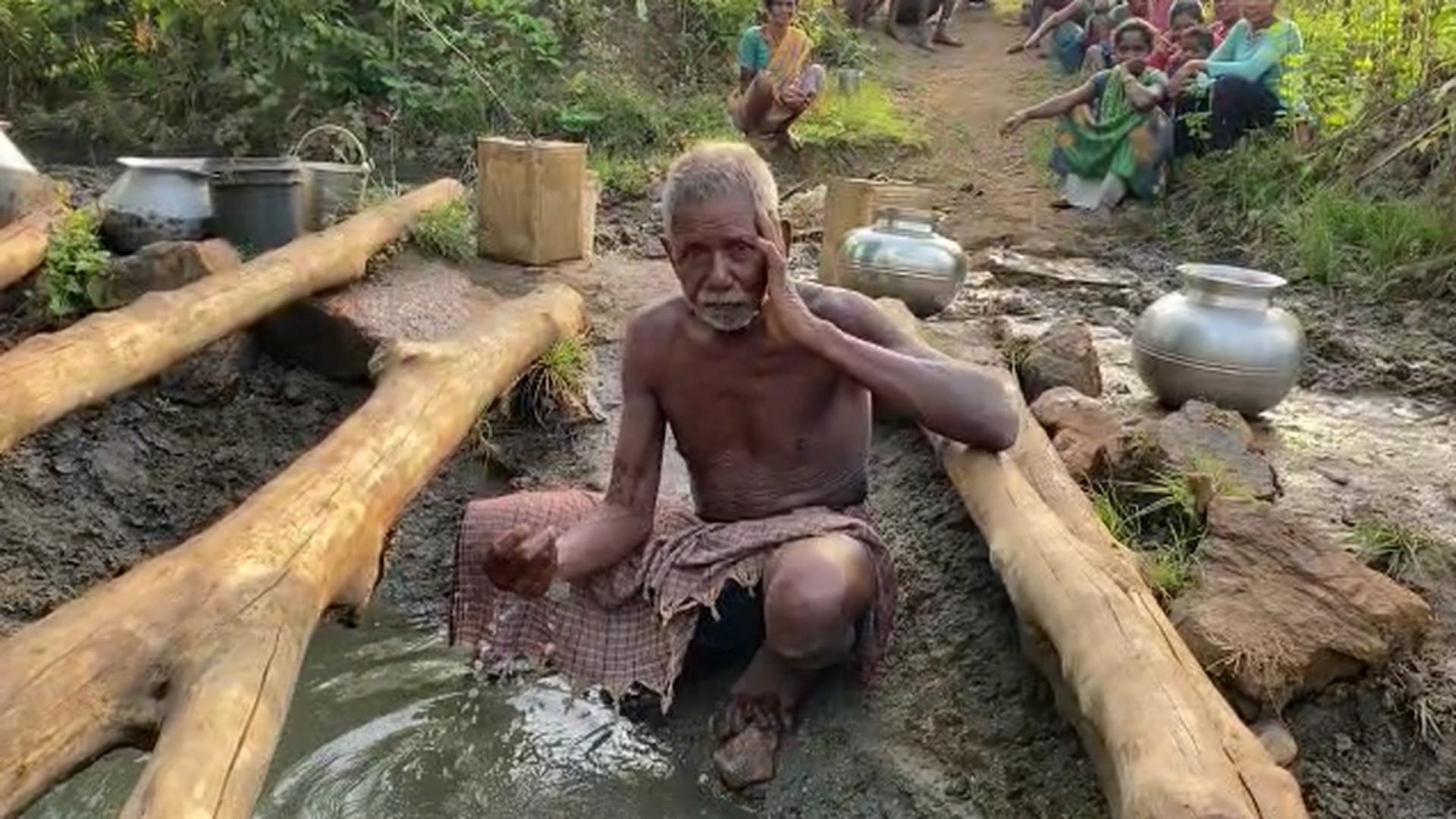 गड्ढे में भरा पानी दिखाता बुजुर्ग। इसी से पूरा गांव अपनी प्यास बुझा रहा है।
