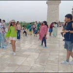 ताजमहल की जर्जर रैलिंग पर बैठे पर्यटक।