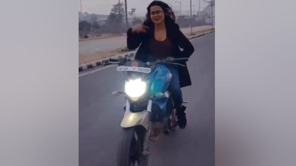 Stunt on moving bike by leaving both hands of girl on Garhwali song in Dehradun