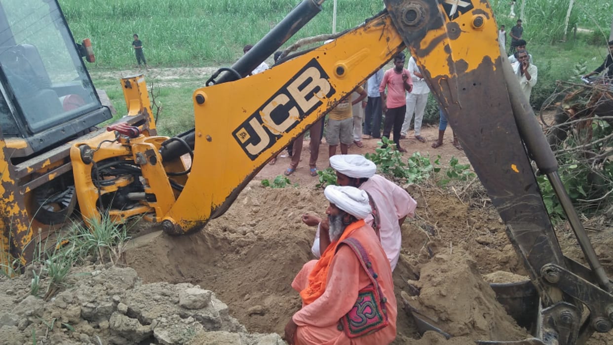 Baghpat: Sadhus have protested against the action of the authorities, lay down in front of the JCB