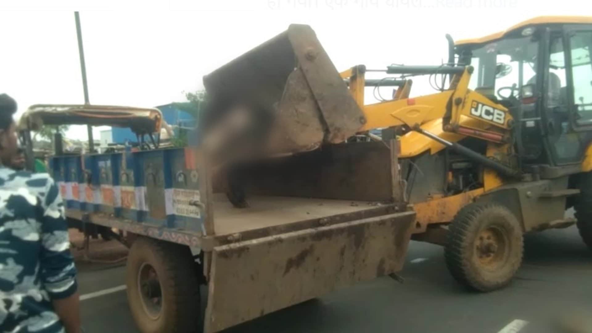 गायों के शवों को ले जाने की तैयारी करते कर्मचारी