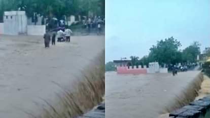 तेज बहाव में पुलिया पार करते लोग।