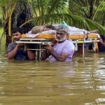 केरल में बारिश का कहर: बुजुर्ग को अस्पताल ले जाते परिजन।