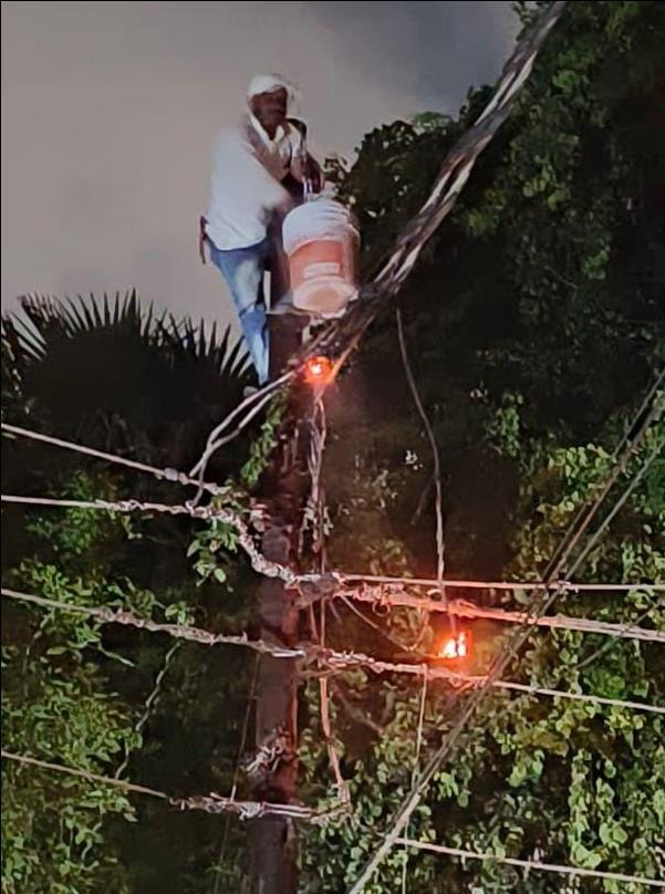 The wire connected to the pole started burning in the night, the electrician climbed with a bucket, extinguish