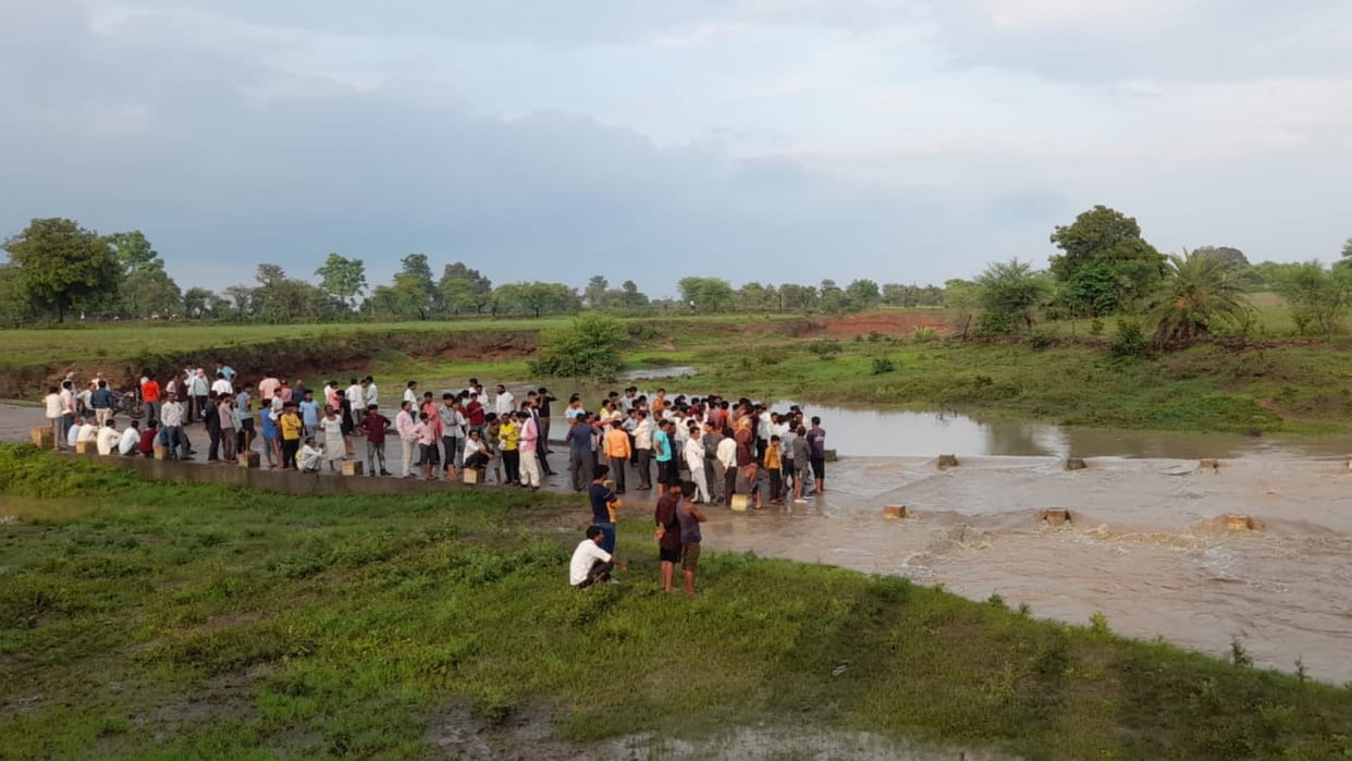 Damoh News Women and men riding bike while crossing the swollen culvert