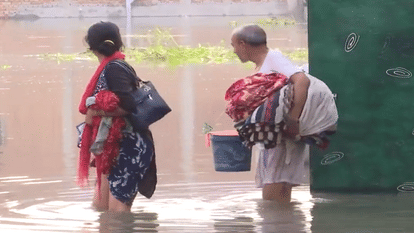 हिंडन नदी में बाढ़ के बाद बाहर निकलते लोग