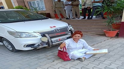High Voltage Drama: डीएम की गाड़ी के सामने बैठी महिला, दूसरी गाड़ी से जाना पड़ा मैडम को, यह है मामला Woman sitting in front of Hathras DM car