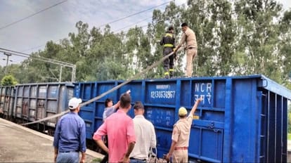 smoke emanating from the wagons of the goods train carrying coal