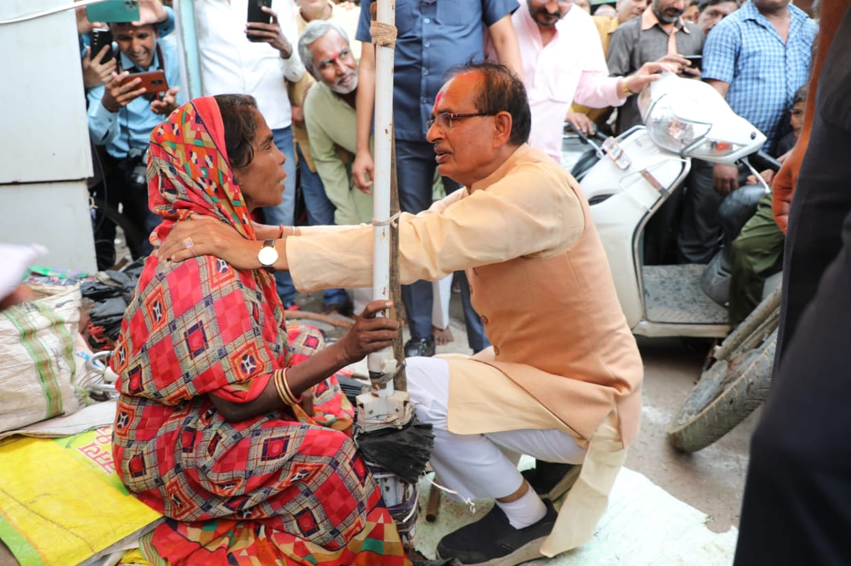 CM Shivraj sitting near an umbrella mender on the footpath in Vidisha, provided financial assistance