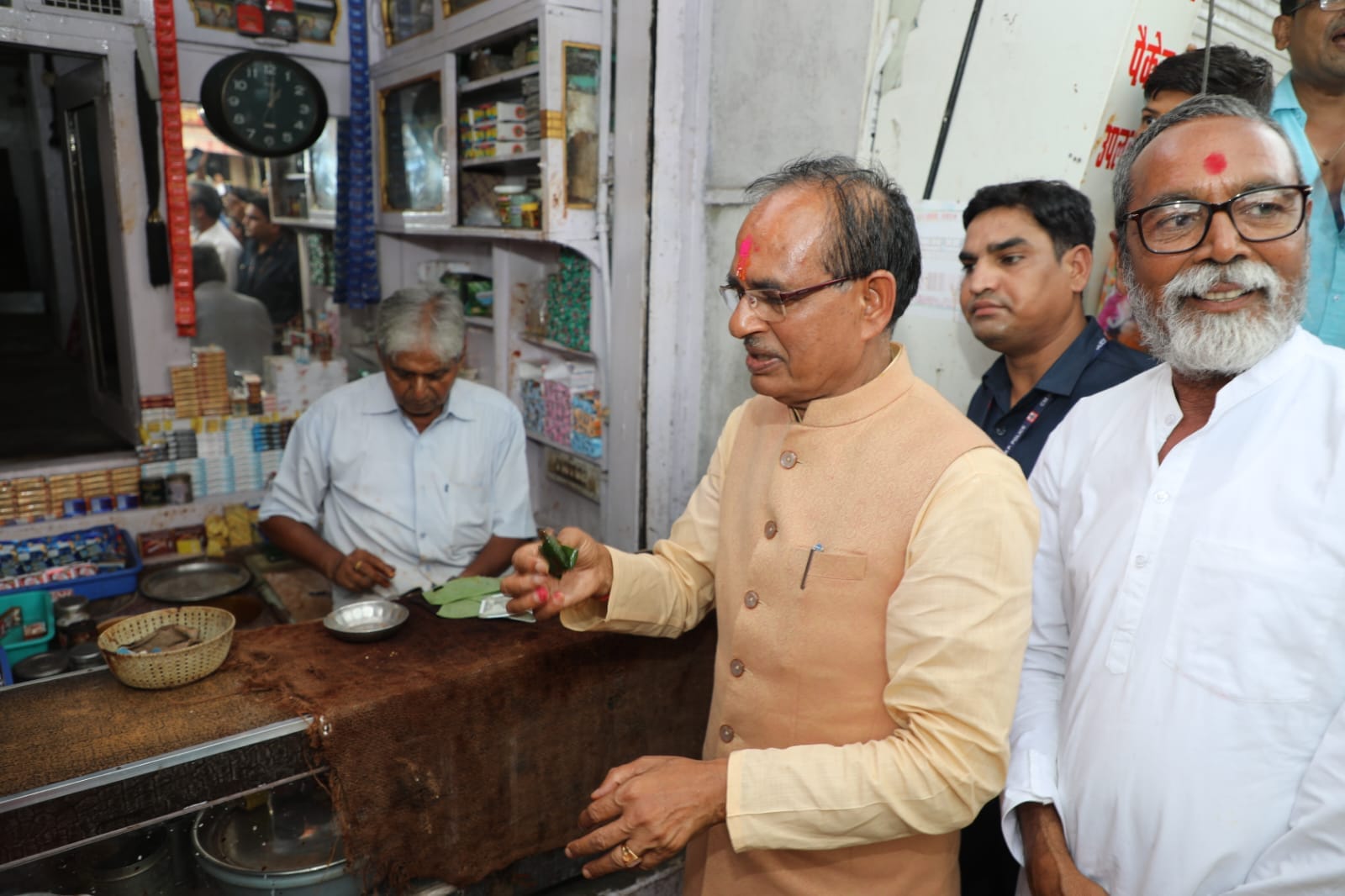 CM Shivraj sitting near an umbrella mender on the footpath in Vidisha, provided financial assistance