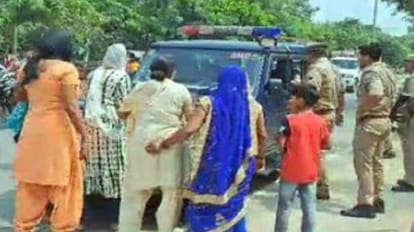 अमरोहा में हंगामा: ट्रैवल एजेंसी संचालक को कोर्ट लेकर जा रही पुलिस की गाड़ी को घेरा, सड़क पर लेट गए परिजन Amroha: Police car carrying travel agency operator court surrounded, family members lying road